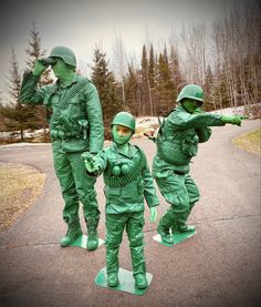 three people in green army uniforms are standing on skateboards and posing for the camera