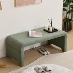 a green bench sitting in the middle of a living room next to a white rug