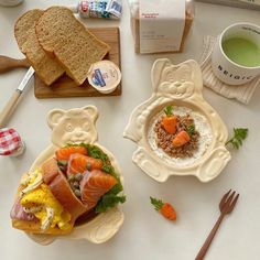 there are two plates with food on them next to cups and spoons, along with other items