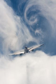 an airplane is flying through the clouds in the sky