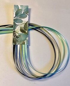 four pieces of ribbon with leaves on them, one is blue and the other has green