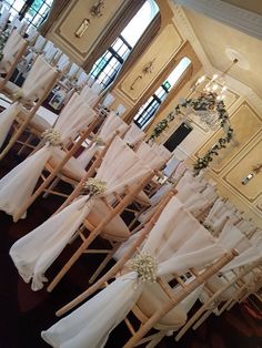 rows of chairs with white table cloths on them