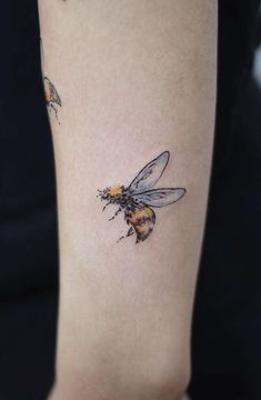 a woman with a bee tattoo on her arm