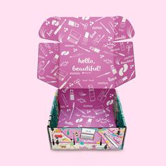 an open pink box with various items in it on a pink background and the words hello beautiful written across the lid