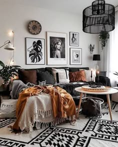 a black and white living room with pictures on the wall, couches, rugs and coffee table