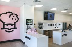 the interior of an office with pink walls and black writing on the wall that says hello kitty