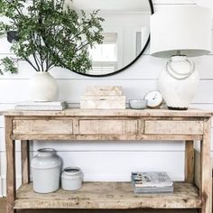 a wooden table sitting under a mirror next to a stair case