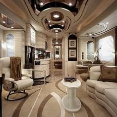 the interior of a luxury motor home with white furniture and large round mirrors on the ceiling