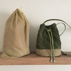 two bags sitting next to each other on top of a wooden shelf in front of a white wall