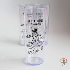 two plastic cups with designs on them sitting next to each other in front of a white background