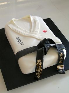 a cake that is on top of a black and white mat with a ribbon around it