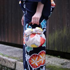 a woman is holding a purse with a bow on the handle and her hand in it