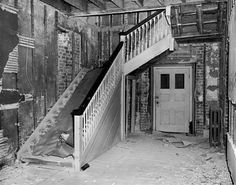 an old photo of a staircase going up the side of a brick building in black and white