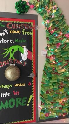 a decorated christmas tree next to a chalk board