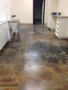 an empty kitchen with dirty floors and white cupboards on either side of the door