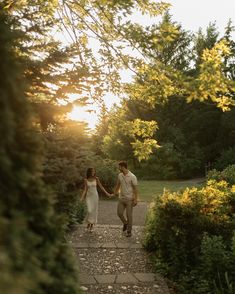 a couple walking down a path holding hands