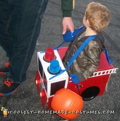 a little boy sitting in a fire truck toy