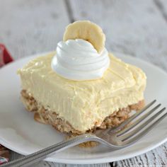 a piece of cake on a white plate with a fork next to it and a banana on top