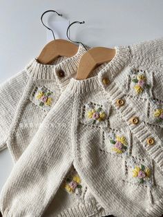 two knitted sweaters with flowers on them