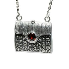 Made of .925 sterling silver. Marcasite embellished pendant. Purse Motif. Oxidized finish. Red CZ accent. Measurements: 27 inch length Material: 925 Sterling Silver, Marcasite Luxury Silver Marcasite Jewelry, Vintage Marcasite Jewelry, Sterling Silver Marcasite, Black Jewelry, Black Rhodium, Locket Necklace, Jewelry Pouch, Rhodium Plated, Locket