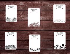 six blank cards with flowers on them sitting on top of a wooden table next to each other