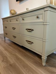 a white dresser sitting on top of a hard wood floor