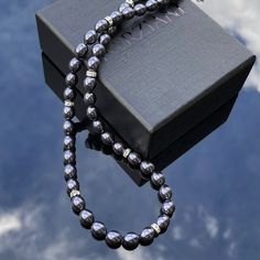 In a world saturated with mediocrity, nothing can rival the authenticity of traditional luxury. This subtly opulent necklace showcases genuine black freshwater pearls, elegantly interspersed with lab diamond silver rondelles. Hand-strung with care in our Orlando studio, this gorgeous necklace is secured with a gold bonded lobster clasp. Our Men's Pearls Collection, features sophisticated fresh water pearl necklaces and bracelets, designed especially for men. Drawing inspiration from historical r Elegant Black Beaded Jewelry, Elegant Formal Jewelry With Black Beads, Elegant Black Beaded Jewelry For Formal Occasions, Elegant Formal Black Beaded Jewelry, Luxury Black Pearl Chain Necklace, Elegant Black Rondelle Beaded Necklaces, Elegant Black Beaded Necklaces, Elegant Black Beaded Pearl Necklace, Elegant Pearl Necklace With 8mm Beads As Gift