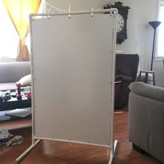 a white board sitting in the middle of a living room next to a couch and table