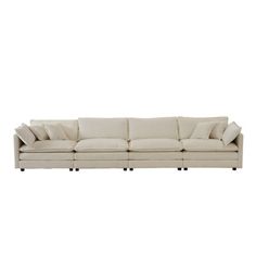 a white couch with four pillows on it's back and one arm facing the camera