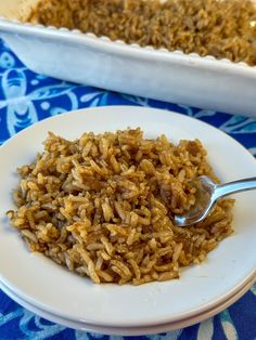 a white plate topped with rice next to a casserole dish