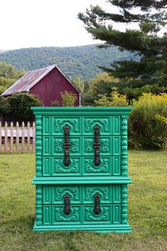 a green dresser sitting in the middle of a field