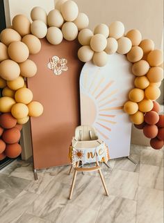 a baby's highchair in front of a backdrop made out of balloons