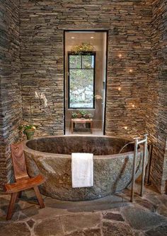 a large stone bathtub sitting in front of a window