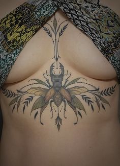 a woman's stomach with a bee tattoo on it