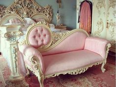 a pink couch sitting on top of a rug next to a bed