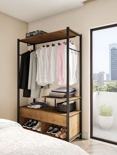 an open closet with clothes and shoes hanging on the rack, next to a bed