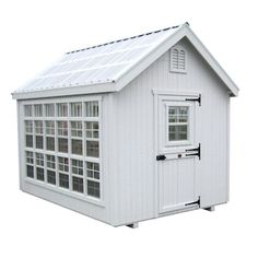 a small white shed with windows on the side