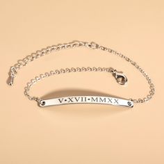 a silver bracelet with the word vxvimmmx on it and a chain attached to it