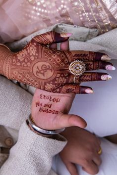 a woman's hand with henna tattoos on it