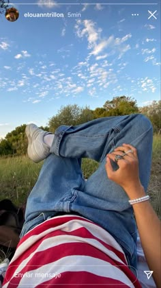 a person laying down in the grass with their feet up