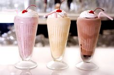 three different types of milkshakes on a table