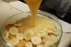 a person pouring orange juice into a bowl filled with sliced bananas