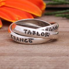 "The Triple Name Ring is our best seller and one of Oprah's Favorite Things!  This triple interlocking ring can be personalized with names, significant dates, or special words.  It is up to you to create your custom name ring! Customization ideas:  family ring, mother's ring, in memorium ring, inspirational ring, survivor ring, class ring, adoption ring, pet ring Stamped with up to 12 characters per band Available in either our Nelle or Lizzy font Sterling silver bands are approximately 3mm wide Customization Ideas, In Memorium, Hand Stamped Ring, Triple Ring, Interlocking Ring, Oprahs Favorite Things, Family Rings, Mom Ring, Name Ring