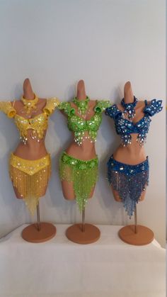 three mannequins with different colored sequins on them