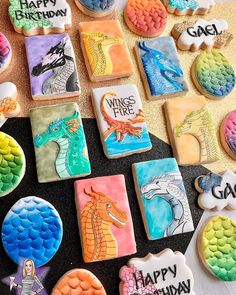 decorated cookies are arranged on a table with happy birthday written in icing and dragon images