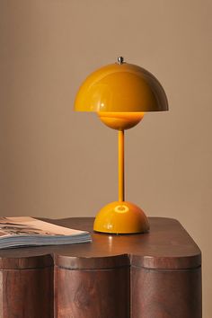 a yellow lamp sitting on top of a wooden table