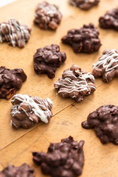 chocolate cookies with white icing and sprinkles on a cutting board