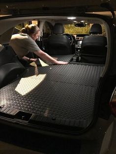 a woman in the back seat of a vehicle with her hand on the floor mat