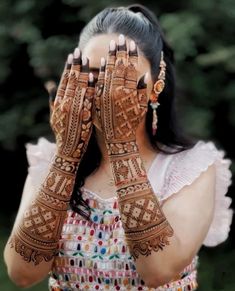 a woman with her hands covering her face and arms covered in hendikes,