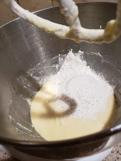 a metal bowl filled with white powder and a whisk